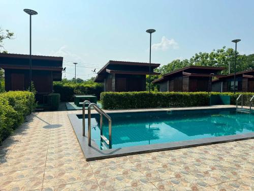 a swimming pool in front of a house at OYO 75500 Kuunone Art & Gallery in Chiang Mai