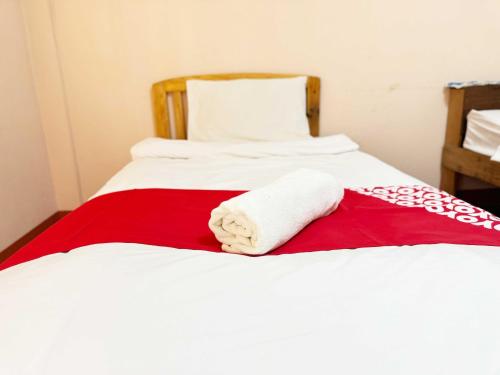 a bed with a red and white towel on it at Honeyland Resort in Chiang Mai