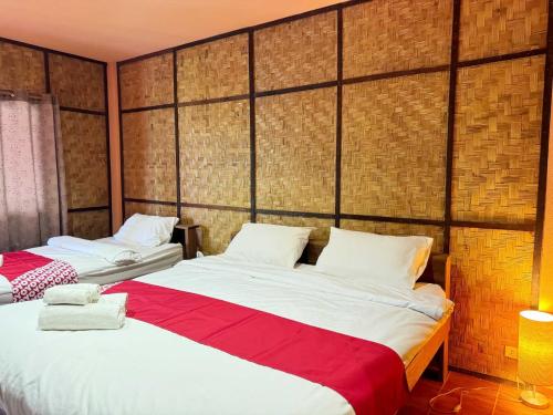 a bedroom with two beds with red and white sheets at Honeyland Resort in Chiang Mai