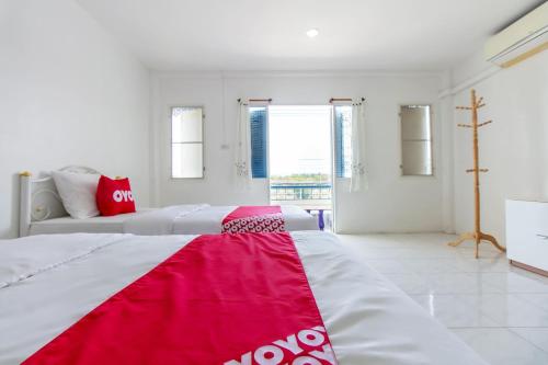 a bedroom with two beds and a red and white blanket at Sabai Place in Hua Hin