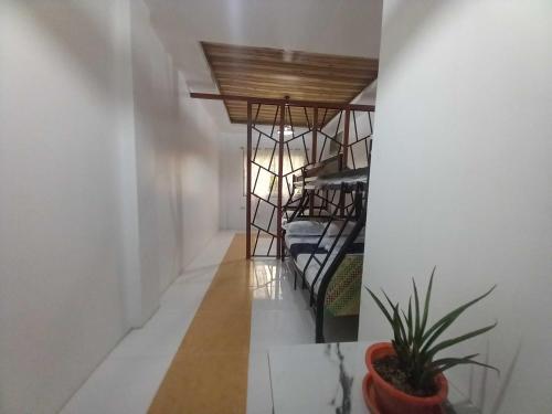 a spiral staircase in a room with a potted plant at OYO 1130 Thrivers Hometel in Puerto Galera