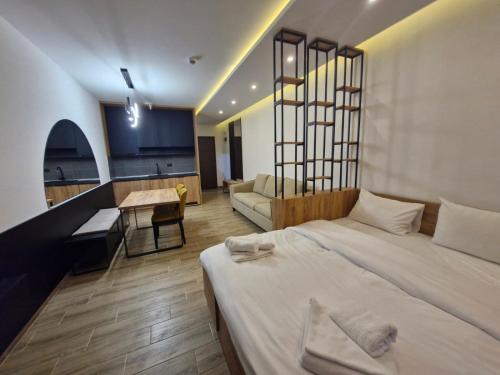 a bedroom with a large bed and a living room at RELAX RESIDENS-kopaonik in Kopaonik