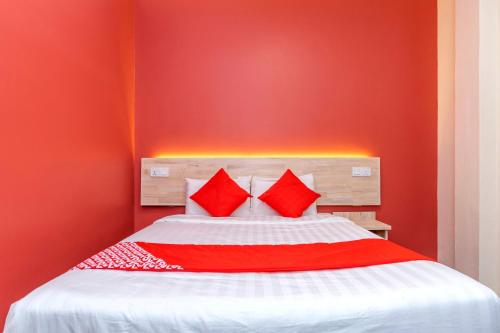 a red bedroom with a bed with two red pillows at OYO 778 Bmw 2 Hotel in Muar