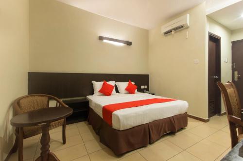 a hotel room with a bed and a table and chairs at Hotel O Bei King in Sitiawan