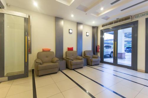 a waiting room with two chairs and a sliding glass door at Hotel O Bei King in Sitiawan