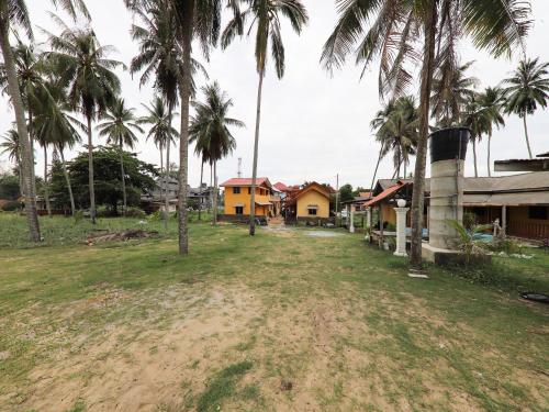 a group of houses and palm trees in a field at Hotel O Bayu Chalet in Kota Bharu