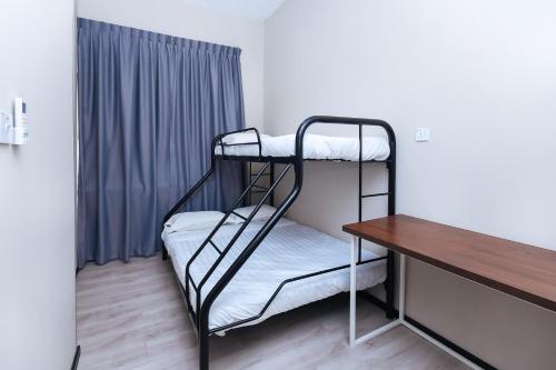 a room with two bunk beds and a desk at Hotel O Lm Residence in Miri