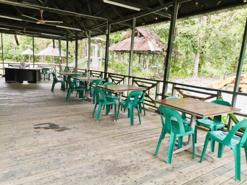 a row of tables and chairs on a wooden deck at Hotel O Flinstone Lodge in Kota Kinabalu