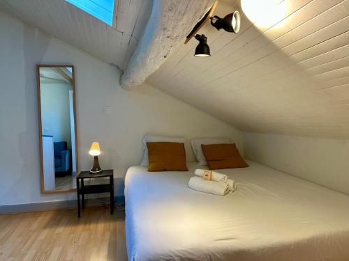 - une chambre mansardée avec un lit et un miroir dans l'établissement Le Nid de Nancy - Studio - 2 personnes - Proche Gare, à Nancy