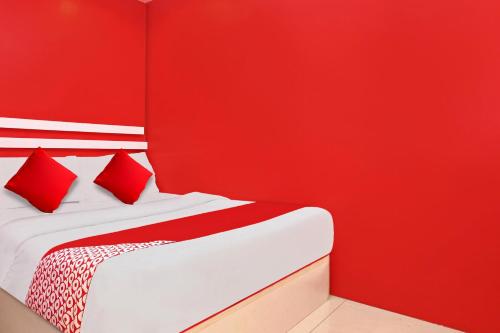a red bedroom with a bed with red walls at Hotel O My New Home Hotel in Gua Musang
