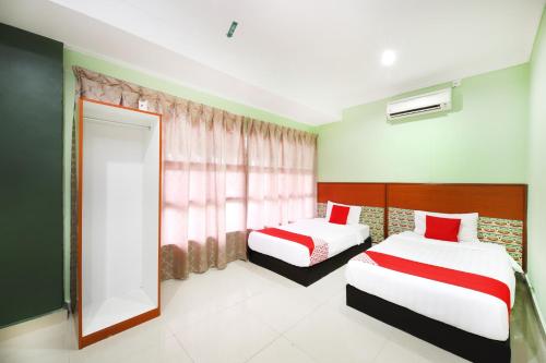 a bedroom with two beds and a window at Super OYO 720 Corridor Hotel 2 in Pekan