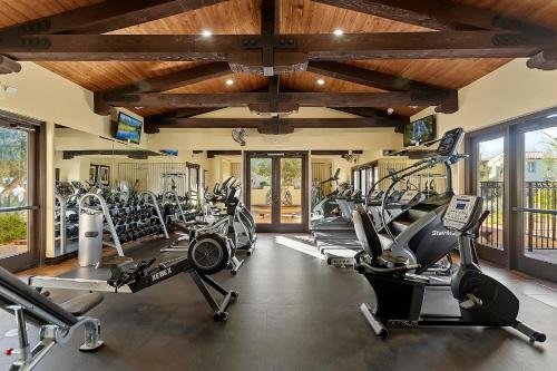 a gym with several treadmills and cardio machines at Spanish Walk Villa - PD condo near acrisure in Palm Desert