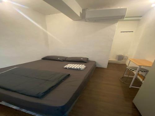 a small room with a bed and a table at Hotel O J Stay Guesthouse in Jelutong