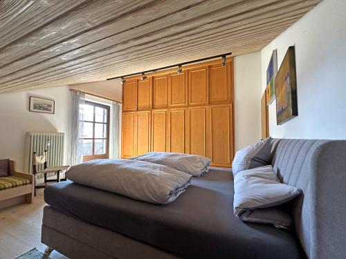 a bedroom with a bed and a couch in it at Ferienwohnung Haus Kampenwand Löhr in Aschau im Chiemgau