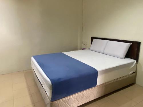 a bed with a blue and white mattress in a room at Hotel O Gold Hill Hotel in Jerantut