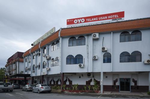 a white building with a sign on top of it at Super OYO 1018 Telang Usan Hotel Miri in Miri