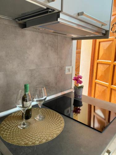 two glasses of wine on a table in a kitchen at Easy Suite Roma San Pietro in Rome