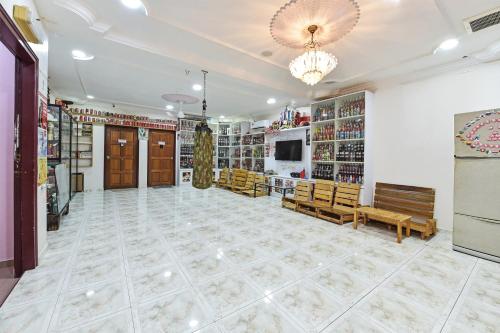 a large room with benches and a chandelier at Hotel O Coke Guest House in Masjid Tanah