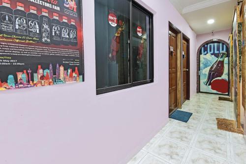 a hallway with two posters on the wall and a door at Hotel O Coke Guest House in Masjid Tanah
