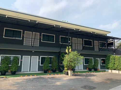 a black building with a tree in front of it at IMM Resort in Bangkok