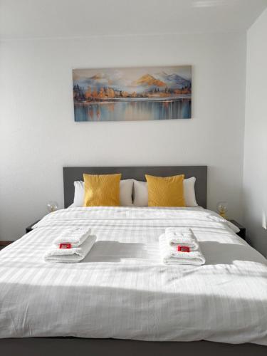 a bedroom with a white bed with two towels on it at Wohlfühl-Apartment in Monheim in Monheim