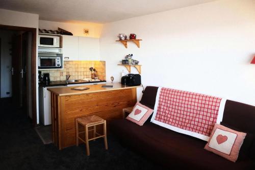 - une cuisine avec un canapé et des oreillers dans l'établissement Résidence Le Cairn - Studio pour 4 Personnes 791, aux Orres