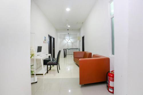 a living room with a couch and a desk at Hotel O Come Inn Premium in Kuala Terengganu