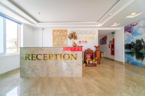 a reception in a room with a sign on the floor at Capital O 215 An Duc Hotel Da Nang in Danang