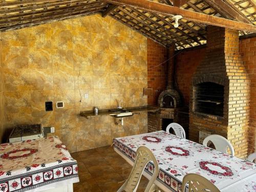 ein Esszimmer mit einem Tisch und einem Backofen in der Unterkunft Chalé Casa da Barra in Barra de São Miguel