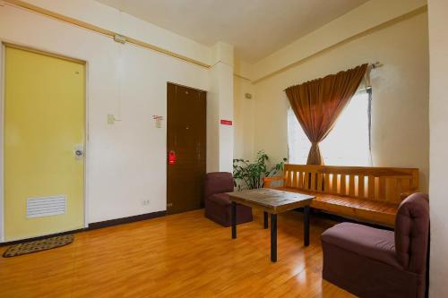 a living room with a bench and a table at OYO 431 Apollo 11 Apartelle in Manila