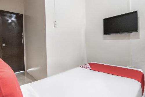 a small room with a bed and a flat screen tv at OYO 431 Apollo 11 Apartelle in Manila