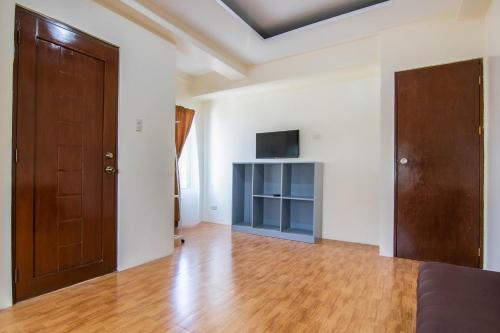 an empty living room with a television and a door at OYO 431 Apollo 11 Apartelle in Manila