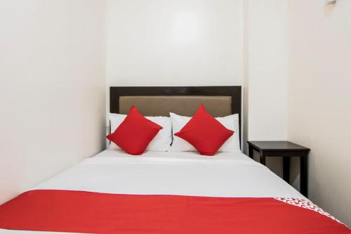 a bedroom with a bed with red and white pillows at OYO 431 Apollo 11 Apartelle in Manila