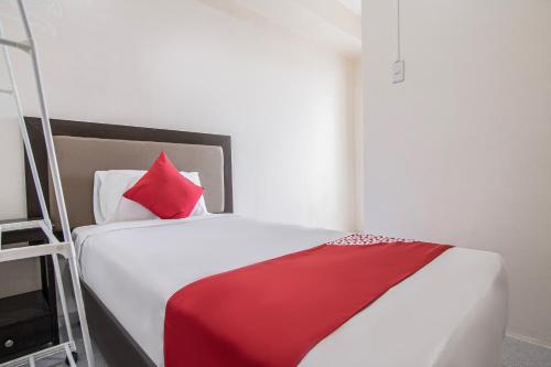 a bedroom with a bed with a red blanket and a ladder at OYO 431 Apollo 11 Apartelle in Manila