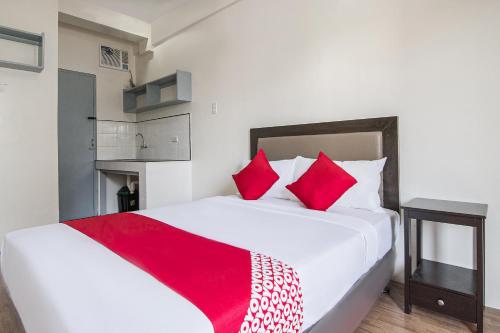 a bedroom with a large white bed with red pillows at OYO 431 Apollo 11 Apartelle in Manila