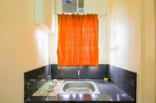 a kitchen with an orange window and a sink at OYO 431 Apollo 11 Apartelle in Manila