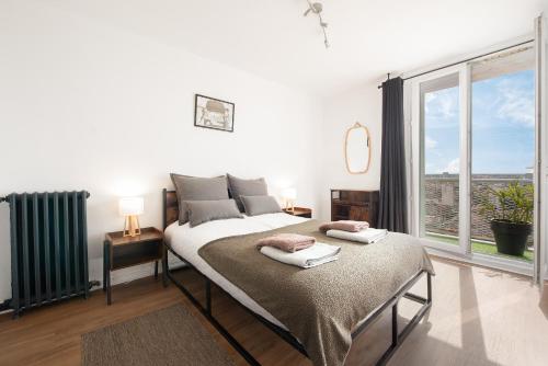 une chambre avec un lit et une grande fenêtre dans l'établissement L Horizon Saint Cyprien, à Toulouse
