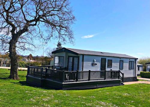 a small blue house with a porch and a tree at Relaxing Retreat with Hot Tub in Saint Helens