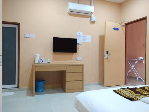 a room with a desk with a tv on the wall at Hotel O Puteri Miqaila in Seri Iskandar