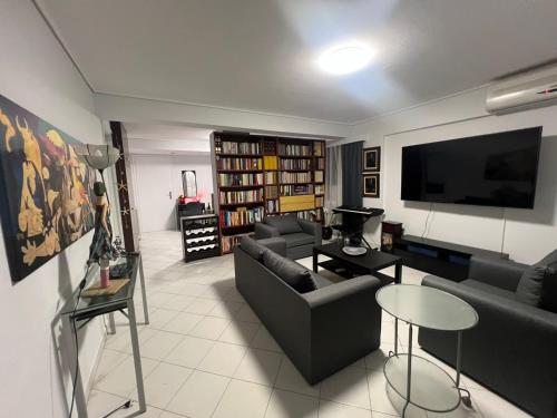 a living room with a couch and a flat screen tv at Artistic & cozy ! Just 5' to seaside in Athens