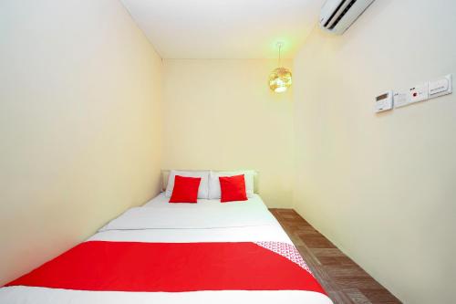 a small room with a red and white bed at OYO 479 The Green Hotel in Ampang