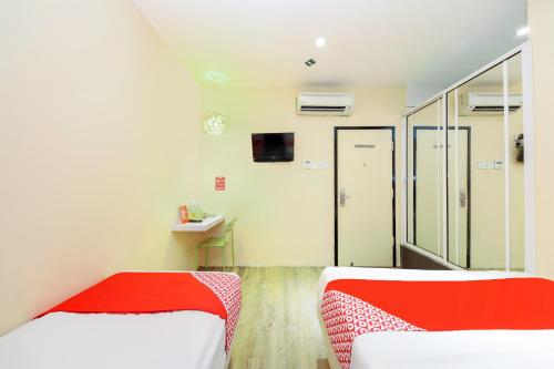 a hospital room with two beds and a tv at OYO 479 The Green Hotel in Ampang