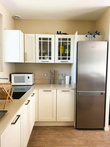 une cuisine avec des armoires blanches et un réfrigérateur en acier inoxydable dans l'établissement Résidence 400-pyla Sur Mer - Maison familiale 8 pers à Pyla-sur-Mer, proche plage MAE-1164, à La Teste-de-Buch
