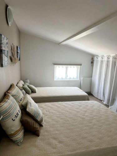 une chambre avec deux lits et une fenêtre dans l'établissement Résidence 400-pyla Sur Mer - Maison familiale 8 pers à Pyla-sur-Mer, proche plage MAE-1164, à La Teste-de-Buch