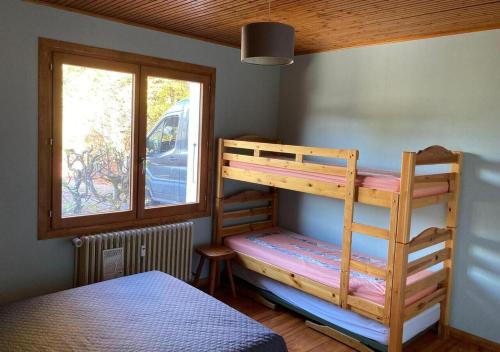 une chambre avec deux lits superposés et une fenêtre dans l'établissement Appartement 6-7 pers, proche activités et loisirs d'été, à La Clusaz