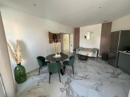 un salon avec une table et des chaises dans l'établissement Maison Bien-être Balnéo et Sauna Cosy et Chaleureux, à Châlons-en-Champagne