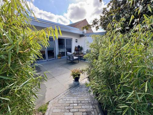 a house with a patio with a chair and plants at B&B Wellness Soest in Soest