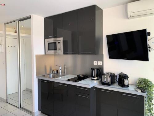 une cuisine avec un évier et un micro-ondes dans l'établissement Résidence Port Nature Colline 5 - Studio 2 personnes Port Nature Colline 5 MAE-5291, au Cap d'Agde