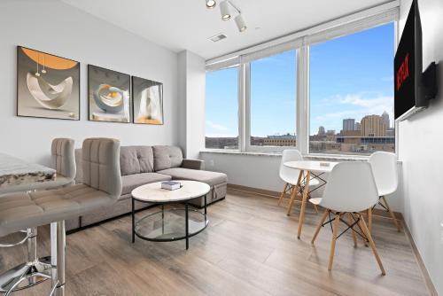 a living room with a couch and a table and chairs at Luxe Condo in Downtown Cleveland l 2 TV's l Parking in Cleveland