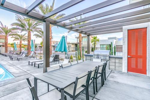 Un patio con mesa y sillas y una piscina. en Mountain View Vibes, en Palm Springs